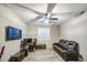The cozy living room features a modern leather sofa, TV, desk, and shuttered window, ideal for relaxing and entertainment at 16042 W Shaw Butte Dr, Surprise, AZ 85379