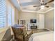This cozy main bedroom features a ceiling fan, shuttered windows, and a comfortable reading chair for a relaxing retreat at 16042 W Shaw Butte Dr, Surprise, AZ 85379