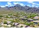 Aerial shot of a neighborhood featuring desert landscaping with lush trees and mountain views at 16861 N 106Th Way, Scottsdale, AZ 85255