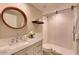 Stylish bathroom with round mirror, marble countertop vanity, and glass-enclosed shower at 16861 N 106Th Way, Scottsdale, AZ 85255