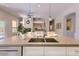 Contemporary kitchen island with stainless steel sink and views into the living space at 16861 N 106Th Way, Scottsdale, AZ 85255