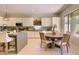 Bright kitchen with island, white cabinets, stainless steel appliances, and modern lighting at 16861 N 106Th Way, Scottsdale, AZ 85255