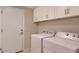 Efficient laundry room with overhead cabinets and modern washer and dryer units at 16861 N 106Th Way, Scottsdale, AZ 85255