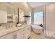 Luxurious bathroom with a double vanity, soaking tub, and modern glass-enclosed shower at 16861 N 106Th Way, Scottsdale, AZ 85255
