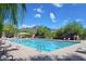 Community swimming pool featuring lap lanes, lounge chairs, mountain views, and mature landscaping at 16861 N 106Th Way, Scottsdale, AZ 85255