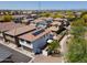An aerial view showing backyard with patio and solar panels on the roof in a residential neighborhood at 17613 N 114Th Ln, Surprise, AZ 85378