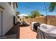 Cozy backyard patio with a dining area, BBQ grill, string lights, and a brick wall border at 17613 N 114Th Ln, Surprise, AZ 85378