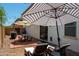 Inviting backyard patio featuring dining furniture, sun umbrellas, and lounge chairs under string lights at 17613 N 114Th Ln, Surprise, AZ 85378