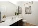 Charming powder room featuring dark vanity, framed mirror, and decorative art at 17613 N 114Th Ln, Surprise, AZ 85378
