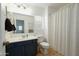 Bright bathroom with a dark vanity, and a shower with a patterned curtain at 17613 N 114Th Ln, Surprise, AZ 85378