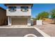 Exterior elevation of a two-story home with a two car garage, tidy landscaping, and blue sky at 17613 N 114Th Ln, Surprise, AZ 85378