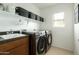 Well-organized laundry room with modern washer and dryer, sink, and ample storage space at 17613 N 114Th Ln, Surprise, AZ 85378