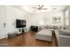 Comfortable living room featuring a large sectional sofa, wood floors, and a ceiling fan at 17613 N 114Th Ln, Surprise, AZ 85378