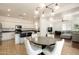 Open floorplan featuring kitchen, dining area, and living room with light fixtures at 17613 N 114Th Ln, Surprise, AZ 85378