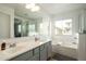 Bright bathroom featuring double sinks, a soaking tub, and a separate shower at 17613 N 114Th Ln, Surprise, AZ 85378