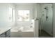 Bright main bathroom featuring a soaking tub and a separate shower at 17613 N 114Th Ln, Surprise, AZ 85378
