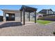 Spacious backyard with artificial turf, gravel, and an elegant dark wood pergola with pavers at 1871 E Lantana Dr, Chandler, AZ 85286
