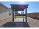 Backyard featuring a dark pergola with pavers, gravel, artificial grass, and privacy walls at 1871 E Lantana Dr, Chandler, AZ 85286