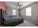 Cozy bedroom with large bed, soft carpet, ceiling fan, and natural light from two windows at 1871 E Lantana Dr, Chandler, AZ 85286