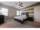 Spacious bedroom with striped accent wall, ceiling fan, and a plush carpet creating a warm inviting space at 1871 E Lantana Dr, Chandler, AZ 85286