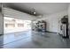 View of spacious three-car garage with clean epoxy flooring and shelving at 1871 E Lantana Dr, Chandler, AZ 85286