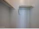 An empty walk-in closet with wooden clothes rods and white walls at 1871 E Lantana Dr, Chandler, AZ 85286