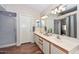 Bright bathroom features double sinks, shower, neutral color palette, and wood-style flooring at 18807 N 42Nd Ave, Glendale, AZ 85308