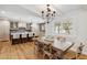 Cozy dining area with a rustic wooden table set under a modern chandelier, adjacent to the kitchen at 2013 E Solano Dr, Phoenix, AZ 85016