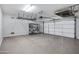 Spacious two car garage with epoxy flooring, storage racks, and an insulated door at 20160 N Riverbank Rd, Maricopa, AZ 85138