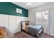 Comfortable bedroom features a decorative green accent wall, a paneled wall, and soft, neutral decor at 20563 E Carriage Way, Queen Creek, AZ 85142
