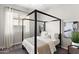 A bright bedroom with a four-poster bed, neutral colors, minimalist decor, and a large window at 20563 E Carriage Way, Queen Creek, AZ 85142