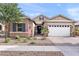 Charming single-Gathering home featuring a two-car garage, a stone facade, and a well-maintained front yard at 20563 E Carriage Way, Queen Creek, AZ 85142