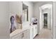 Bright hallway featuring built-in cabinets, decorative accents, and elegant flooring leading to bathroom at 20563 E Carriage Way, Queen Creek, AZ 85142