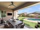 Inviting outdoor patio with a comfortable dining area, ceiling fan, and views of the sparkling pool at 20563 E Carriage Way, Queen Creek, AZ 85142