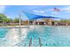 Community splash pool featuring sunshade, playground elements, and clubhouse nearby at 20563 E Carriage Way, Queen Creek, AZ 85142