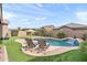 Inviting backyard pool with waterfall feature, comfortable seating, and lush landscaping, perfect for relaxation and entertaining at 20563 E Carriage Way, Queen Creek, AZ 85142
