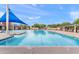 Large community swimming pool featuring sunshade and lounge seating in a quiet neighborhood at 20563 E Carriage Way, Queen Creek, AZ 85142