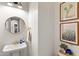 Stylish powder room with modern fixtures, charming artwork, and a decorative mirror at 20563 E Carriage Way, Queen Creek, AZ 85142