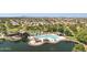 Scenic aerial community shot featuring a pool, clubhouse, palm trees, lake, and well-maintained landscaping at 21019 N Sansom Dr, Maricopa, AZ 85138