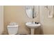 Cozy bathroom with a pedestal sink, round mirror, and toilet, offering a clean and functional space at 21019 N Sansom Dr, Maricopa, AZ 85138