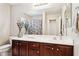 Bathroom vanity with a granite countertop, dark wood cabinets and a large mirror at 21019 N Sansom Dr, Maricopa, AZ 85138