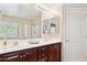 Bright bathroom with double vanity, wood cabinets and a large mirror, providing ample space at 21019 N Sansom Dr, Maricopa, AZ 85138