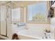 Bright bathroom featuring a separate shower and soaking tub under a window with natural light at 21019 N Sansom Dr, Maricopa, AZ 85138