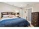 Cozy bedroom with a plush blue comforter, dark wood furniture, and recessed lighting at 21019 N Sansom Dr, Maricopa, AZ 85138
