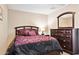 Cozy bedroom with a plush floral comforter, dark wood furniture, and recessed lighting at 21019 N Sansom Dr, Maricopa, AZ 85138