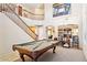 Spacious game room featuring a pool table, staircase, and open floor plan with carpet flooring at 21019 N Sansom Dr, Maricopa, AZ 85138
