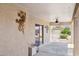 Covered patio with decorative gecko art, ceiling fan, and sliding door access to the serene backyard at 21019 N Sansom Dr, Maricopa, AZ 85138