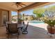 Inviting covered back patio with a dining set overlooking a sparkling pool and desert landscape at 2222 W Morse Ct, Anthem, AZ 85086