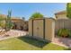 Landscaped backyard featuring a well-maintained lawn, desert plants, and a storage shed at 2222 W Morse Ct, Anthem, AZ 85086