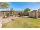 Well-maintained backyard featuring desert landscaping, lush green lawn, storage shed, and block wall at 2222 W Morse Ct, Anthem, AZ 85086